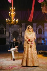 A beautiful South Asian couple in traditional attire during an indoor wedding ceremony.
